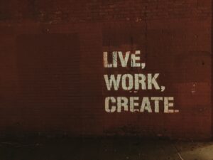 Arte red brick wall with live, work, create. quote