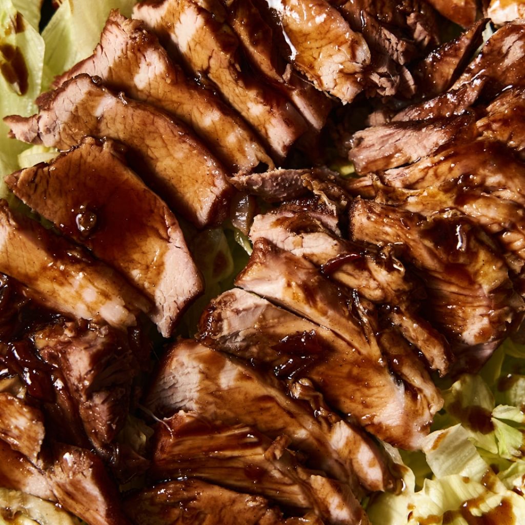 a close up of meat and lettuce on a plate